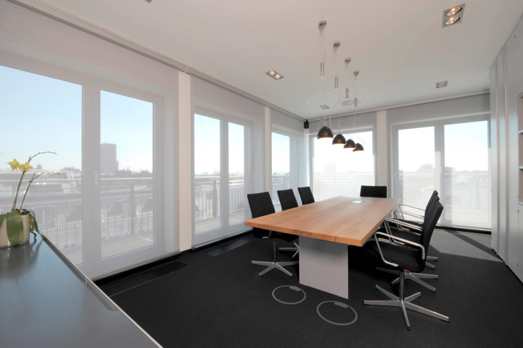 konferenzraumn mit holztisch und stühlen klimik hamurg office interior formwaende