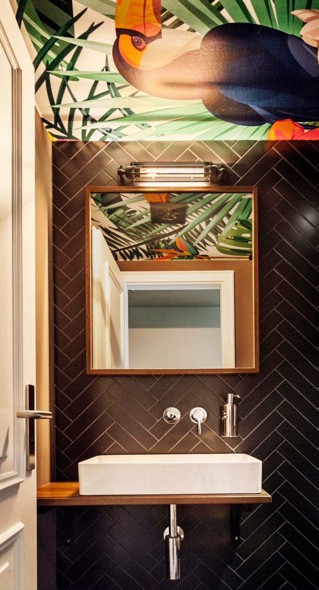 waschbecken und spiegel dunkle fliesen vogel print wellnessbereich landhaus stricker hotel interior design formwaende