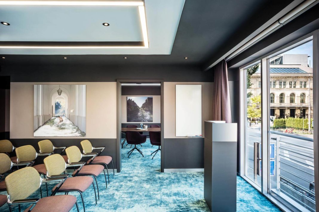 stühle und podium in konferenzraum mit hellen großen fenstern im le meridien münchen hotel interior design formwaende
